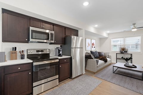 a kitchen with stainless steel appliances and a living room with a couch