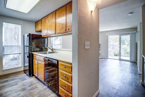 A kitchen with wooden cabinets and a refrigerator.