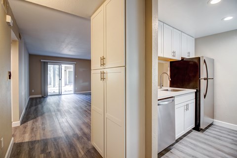 A kitchen with white cabinets and a refrigerator.