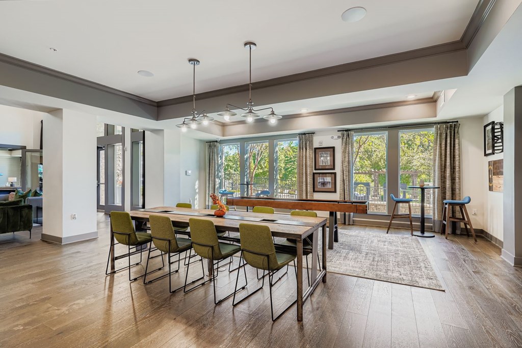 A modern dining room with a long table and chairs.