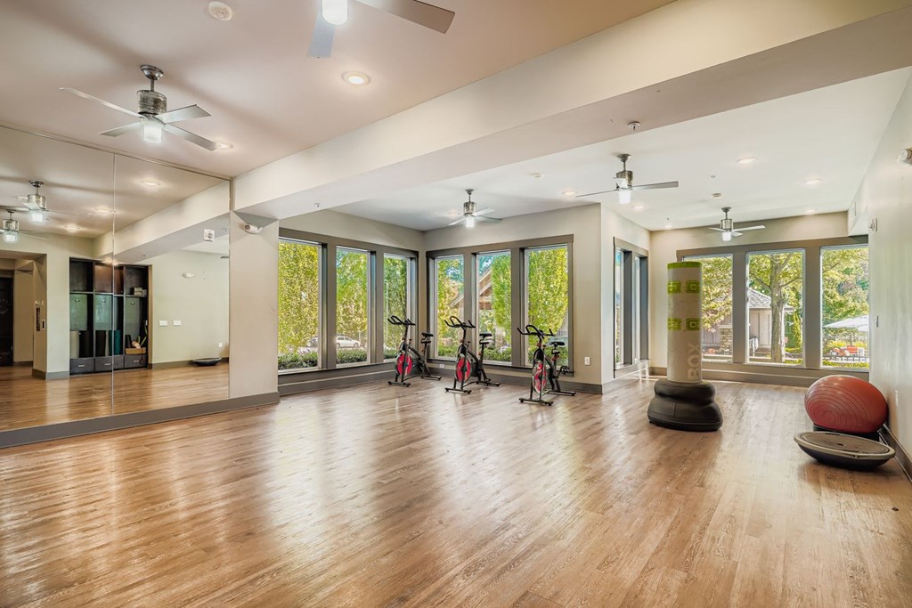 A spacious room with wooden floors and a ceiling fan.