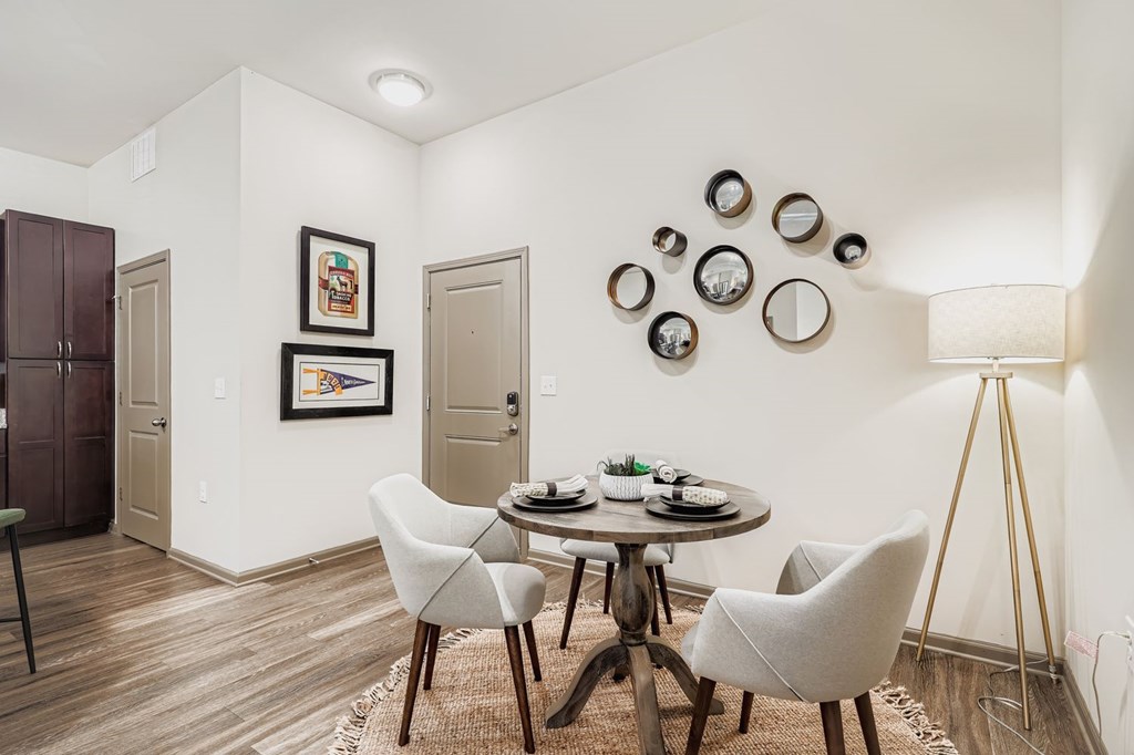 A dining room with a round table and chairs.