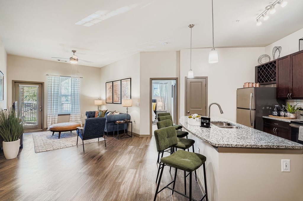A modern kitchen with a dining area and a living room.