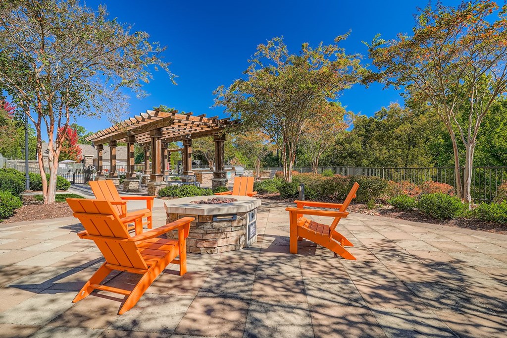 A patio with orange chairs and a gazebo.
