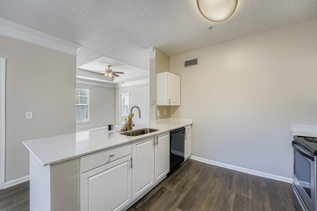 A kitchen with white cabinets and a white counter top.