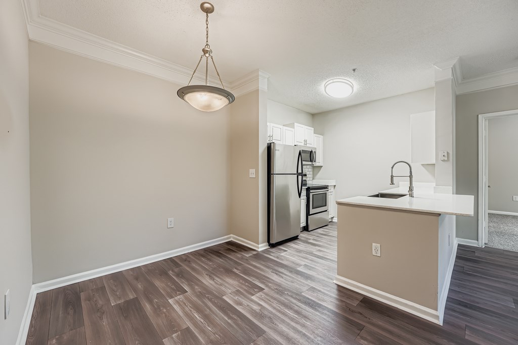 A kitchen with a refrigerator, oven, and sink.