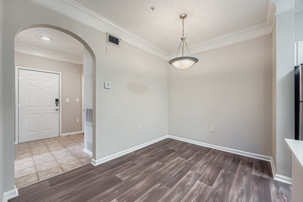 A room with a white door and a light brown floor.