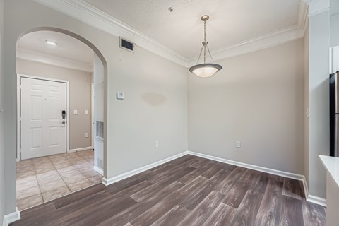 A room with a white door and a light brown floor.
