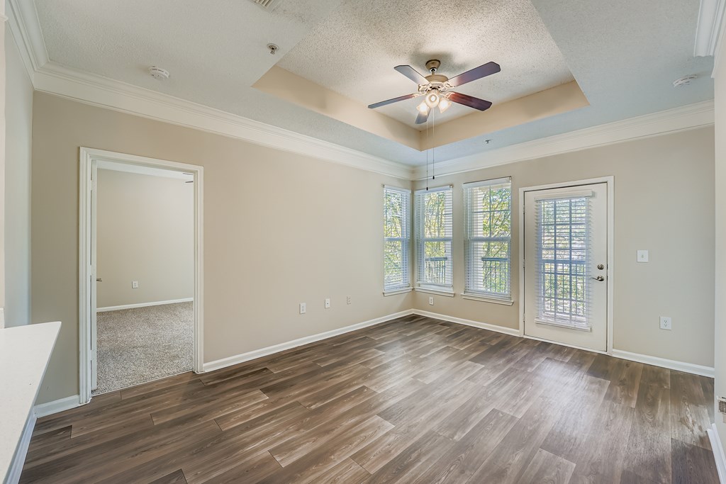 A room with wood flooring and a ceiling fan.