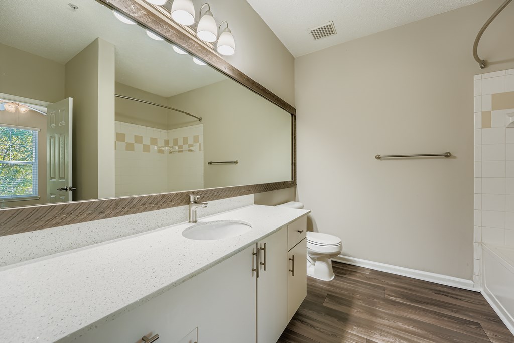 A bathroom with a white countertop and a white toilet.