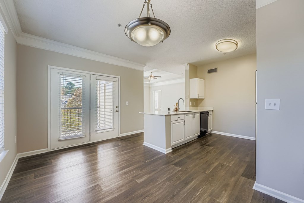 A kitchen area with a wooden floor and a ceiling light.