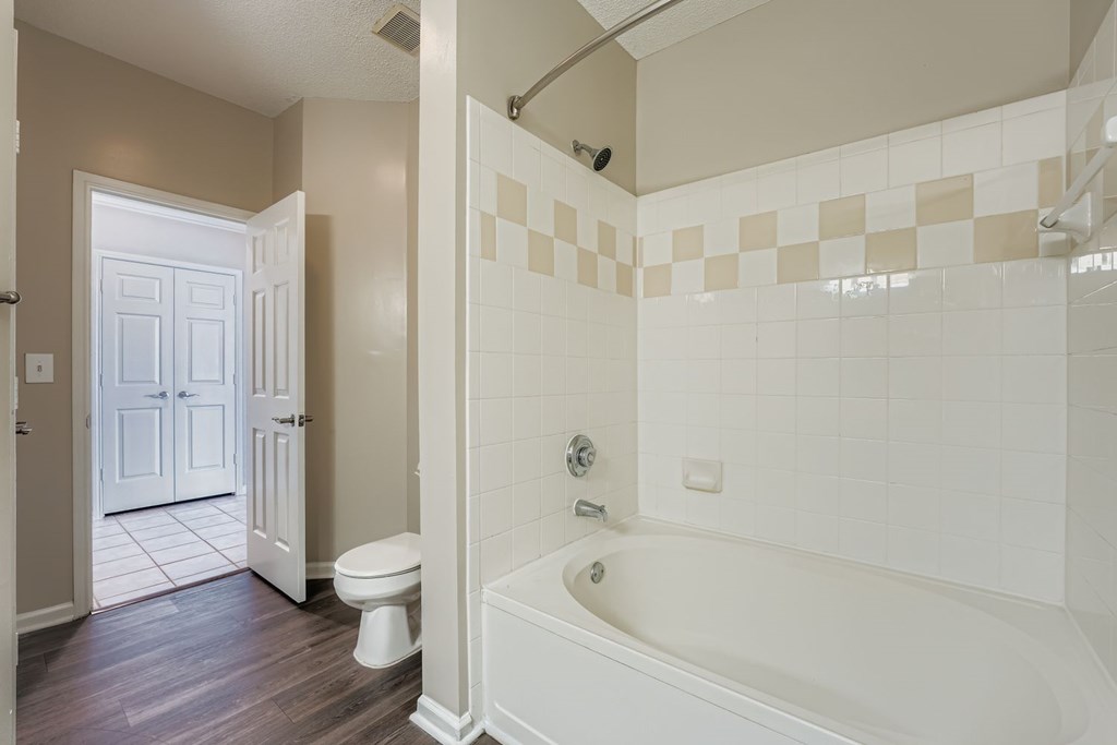 A white bathroom with a tub, toilet and sink.