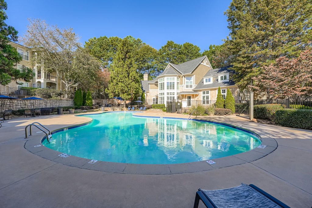 A large swimming pool in front of a house.