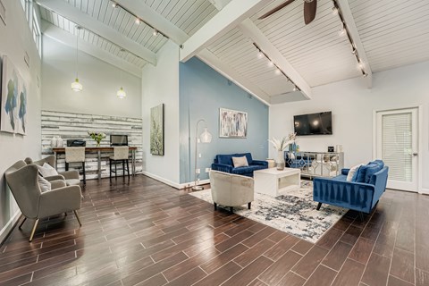 A living room with a blue couch and a dining table.