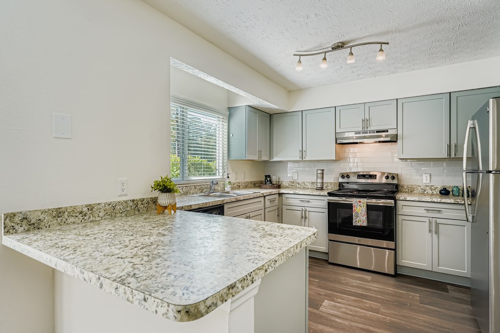 A kitchen with granite countertops and stainless steel appliances.