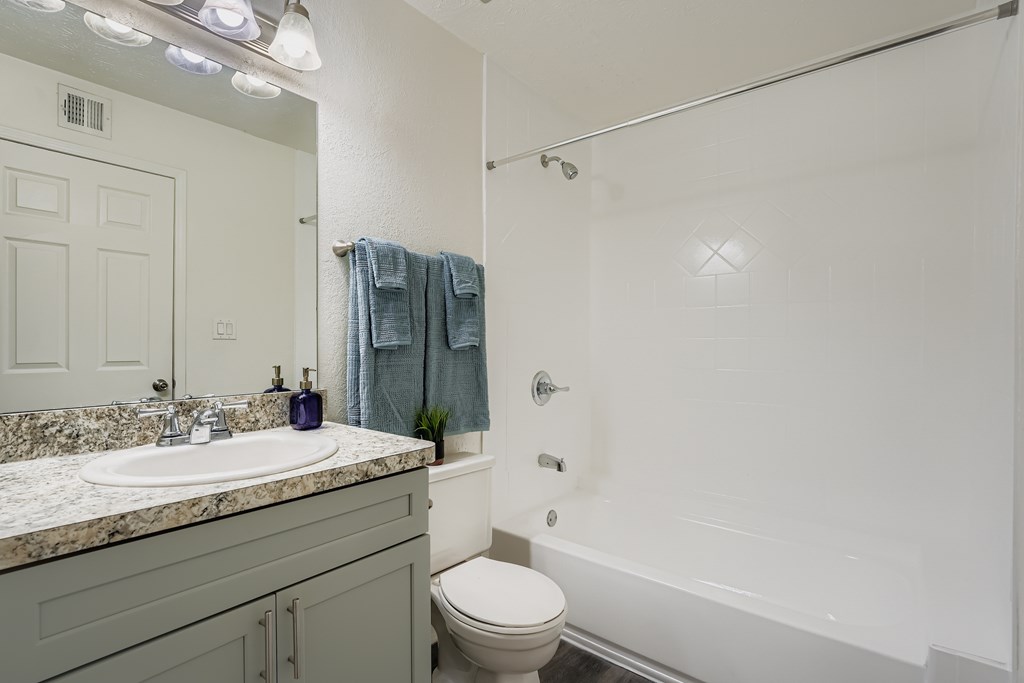 A bathroom with a toilet, sink, and shower.