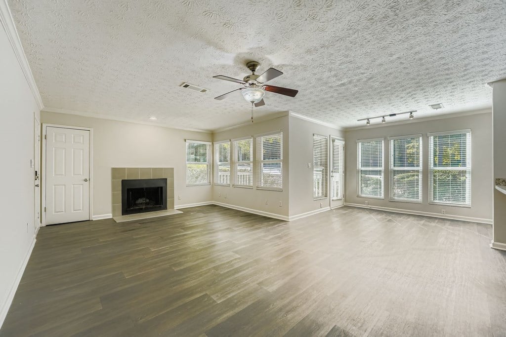 A spacious room with a fireplace and a ceiling fan.