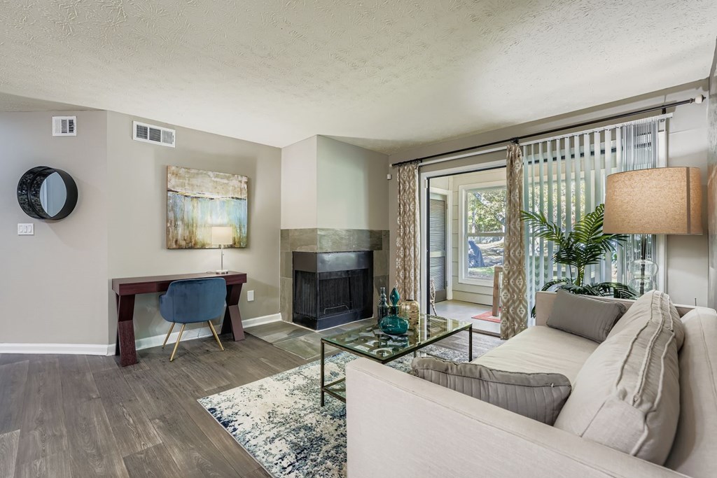 A living room with a couch, a table, and a fireplace.