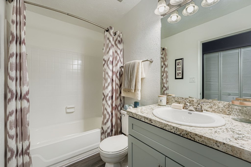 A bathroom with a toilet, sink, and shower.