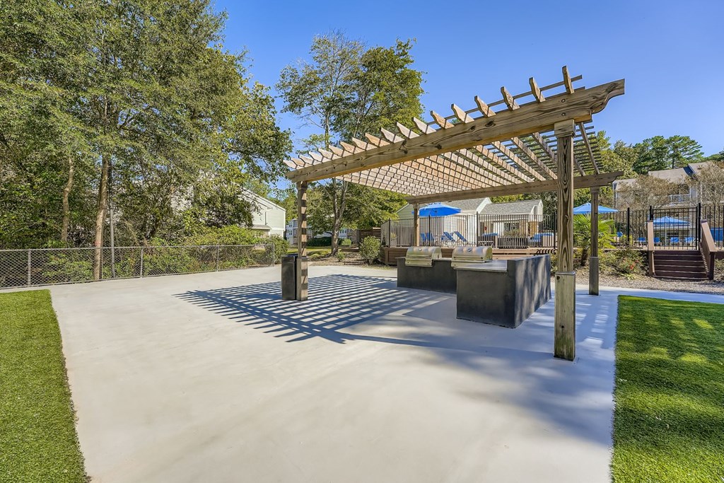 A playground with a wooden pergola and concrete structures.
