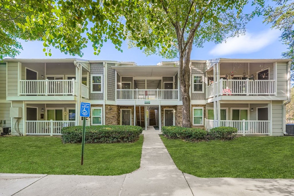 Apartment complex with a blue sign in front.