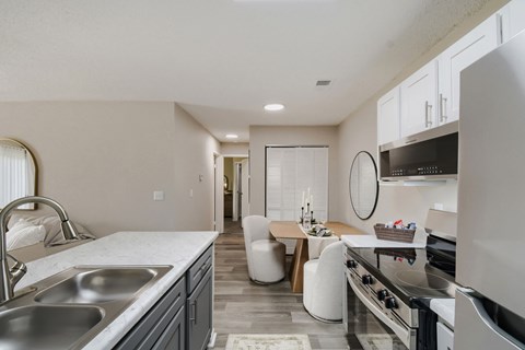 A modern kitchen with a stainless steel sink and oven.