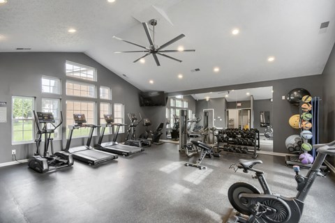 A spacious gym with treadmills, exercise bikes, and other equipment.