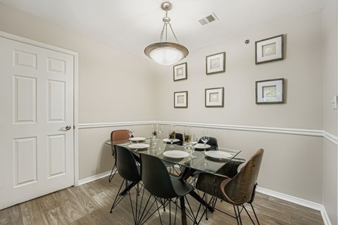 A dining room with a glass table and chairs.