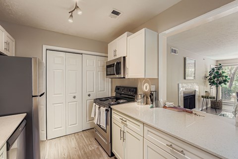 A kitchen with white cabinets and a black stove top oven.