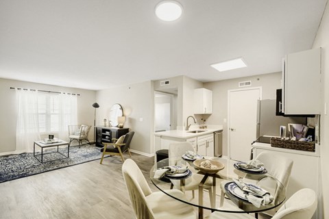 A modern dining room with a glass table and chairs.