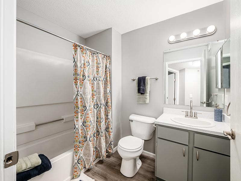 A white toilet sits next to a bathtub in a bathroom.
