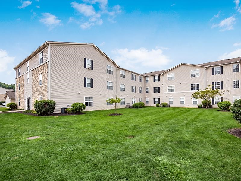 A large apartment complex with a green lawn in front.