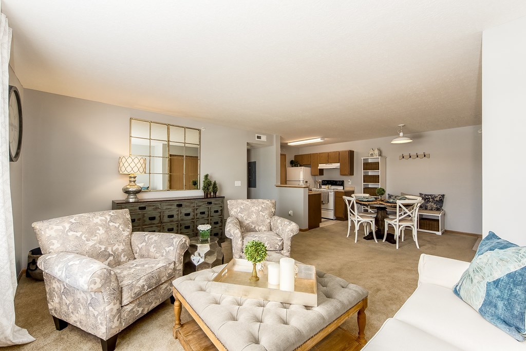 A living room with a white couch, a coffee table, and a dining table.