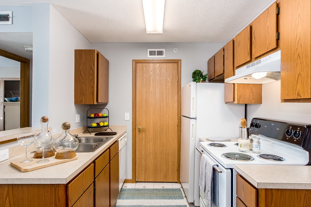 A kitchen with wooden cabinets and a white refrigerator.