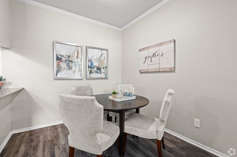 A dining room with a table and chairs.