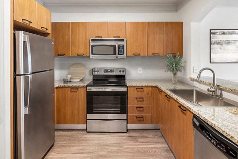 A modern kitchen with wooden cabinets and stainless steel appliances.