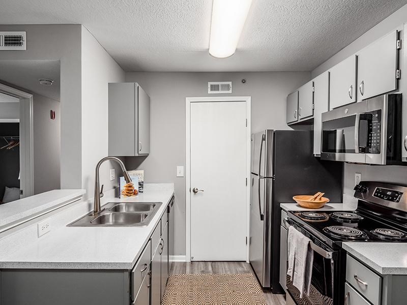 A kitchen with a white sink and black stove.