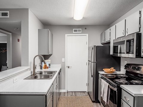 A kitchen with a white sink and black stove.