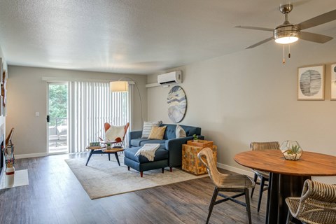 A living room with a blue couch and a wooden table.