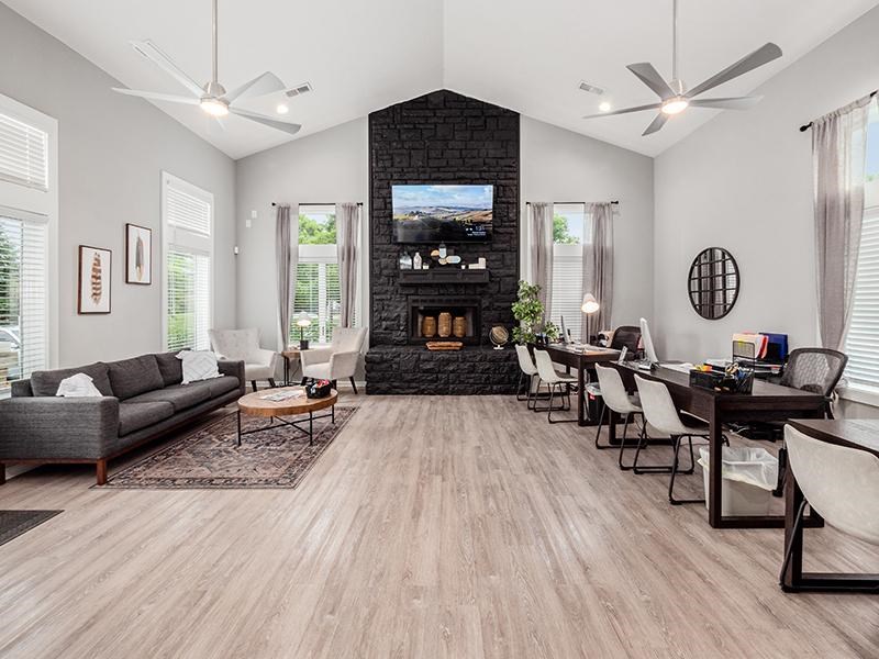 A living room with a fireplace and a grey couch.
