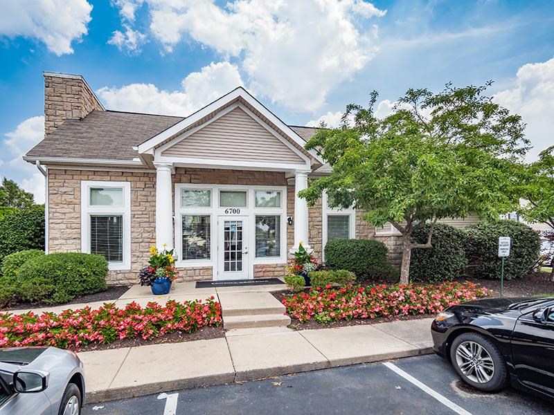 A small house with a black car parked in front.
