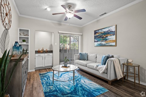 A living room with a white couch and a blue rug.