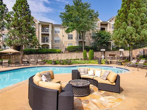 A poolside patio with a couch and a table.