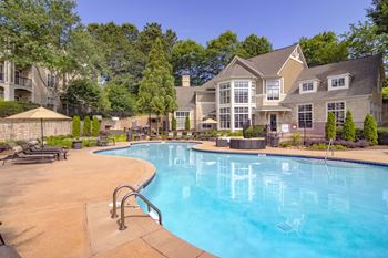 A large swimming pool in front of a house.