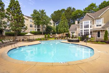 A large swimming pool in a residential area surrounded by houses and trees.