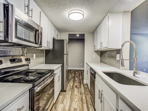 A kitchen with white cabinets and a black stove top oven.