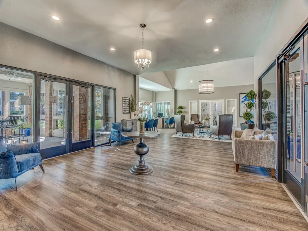 A spacious living room with wooden floors and a variety of seating options.