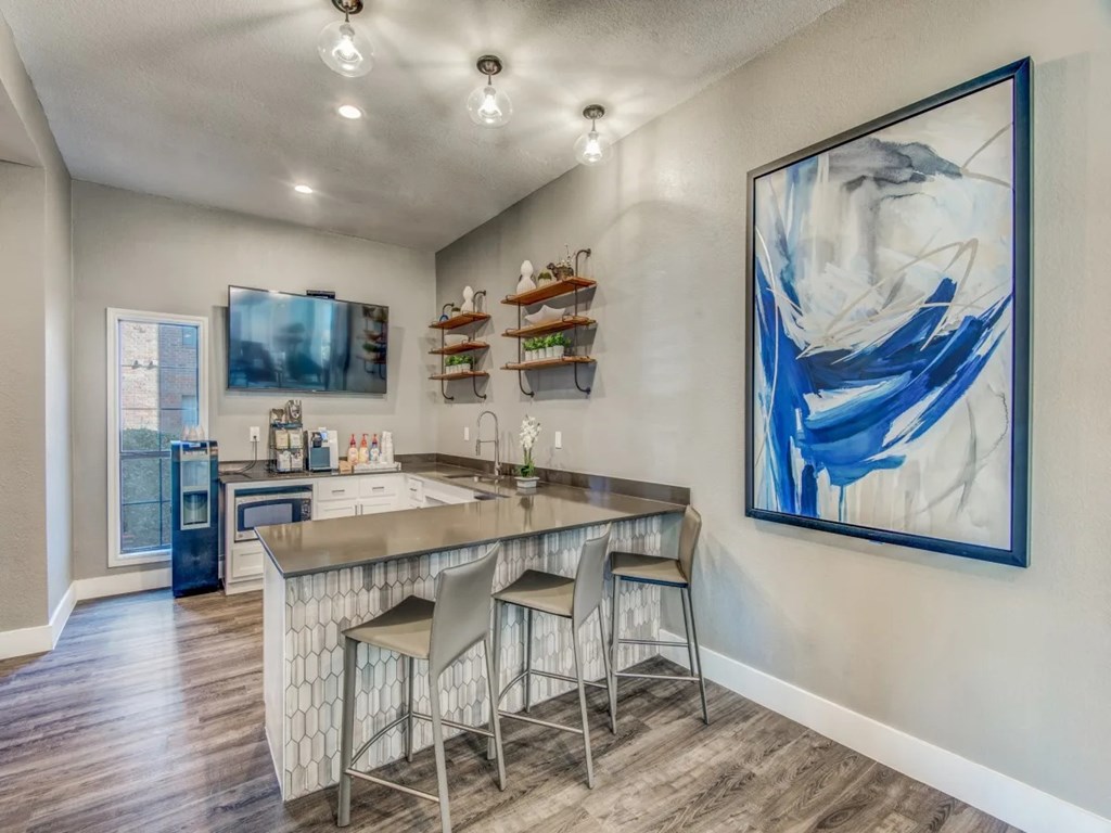 A kitchen with a bar area and a painting on the wall.