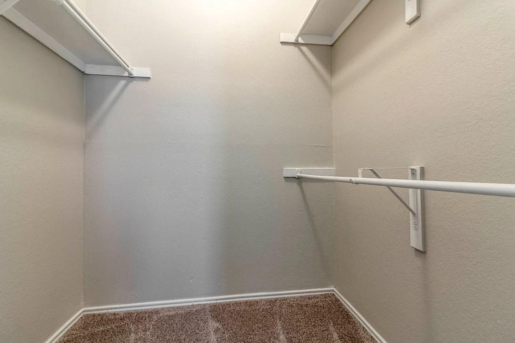 A white wall with a white shelf and a white pipe.