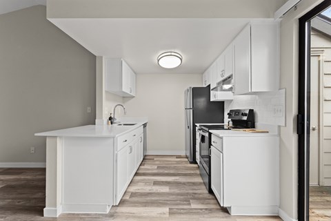 A modern kitchen with white cabinets and appliances.
